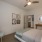 Bedroom interior with decorative art, console table, and doorway to the kitchen.