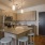 Light-filled Denver apartment kitchen with island, stainless steel appliances, and wood cabinetry.
